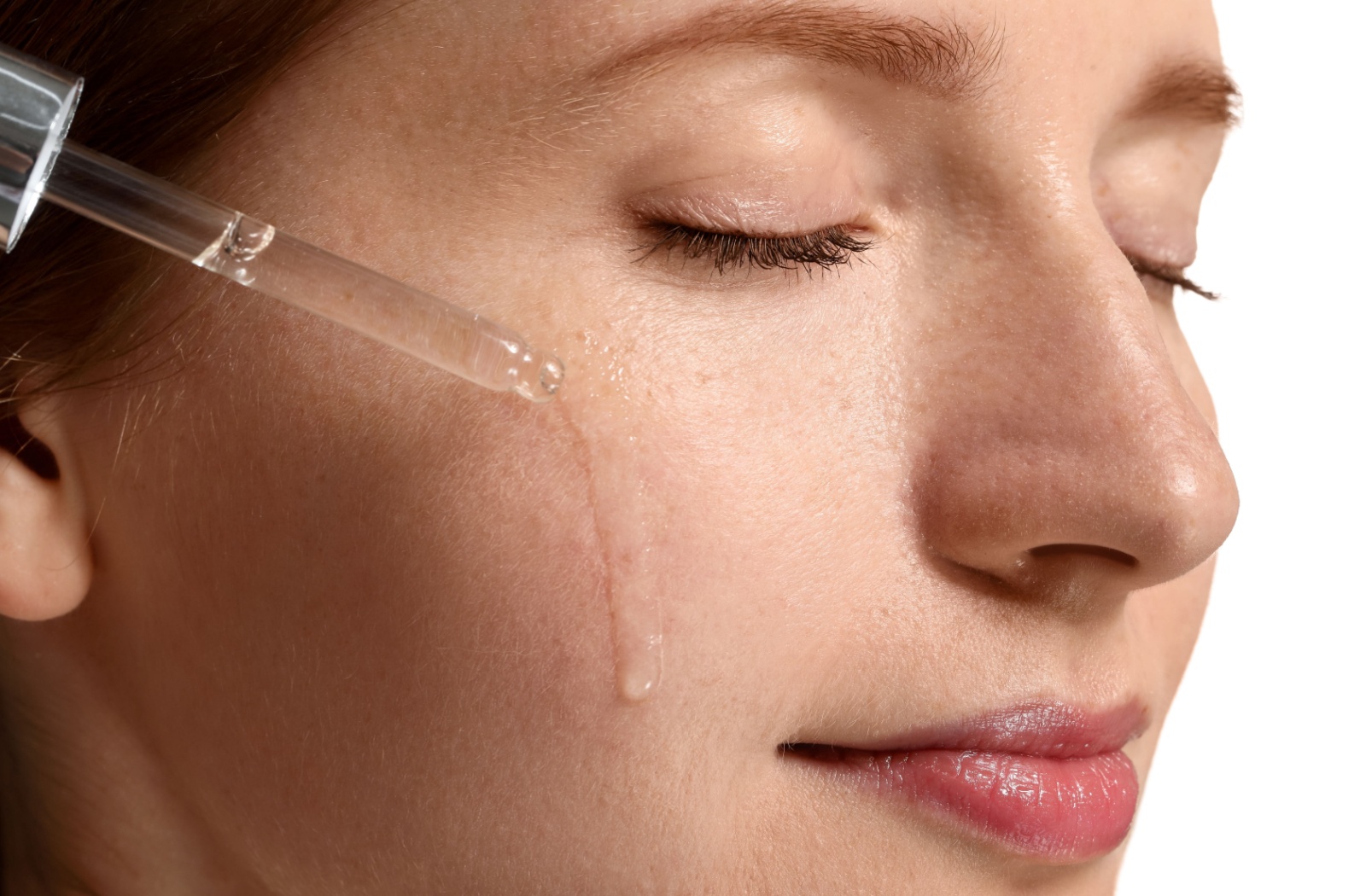 Close up of a person using a serum on their facial skin