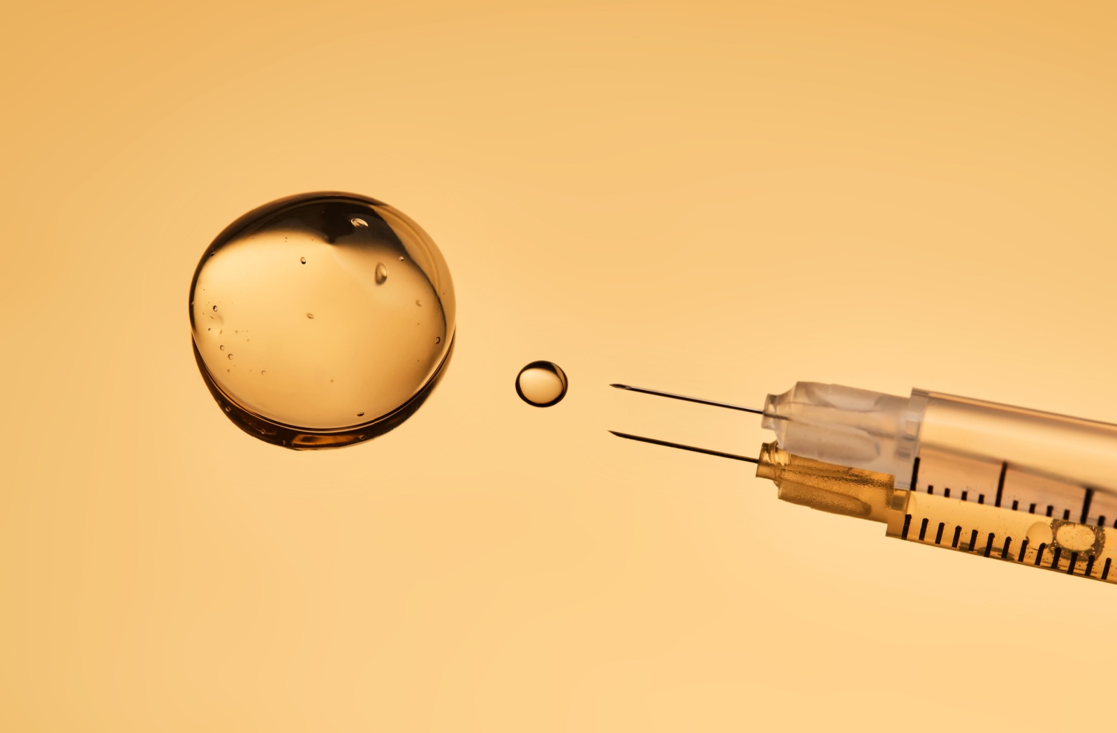 Close up of a botox in a syringe on top of a yellow background